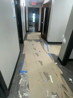 Commercial hallway with floor protection paper, tape and construction debris
