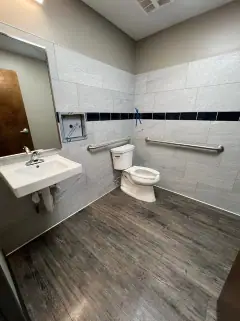 Same restroom after the final clean, with a clean sink, toilet and floor