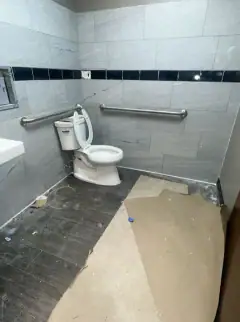 New commercial restroom with protection paper on the floor and construction dust