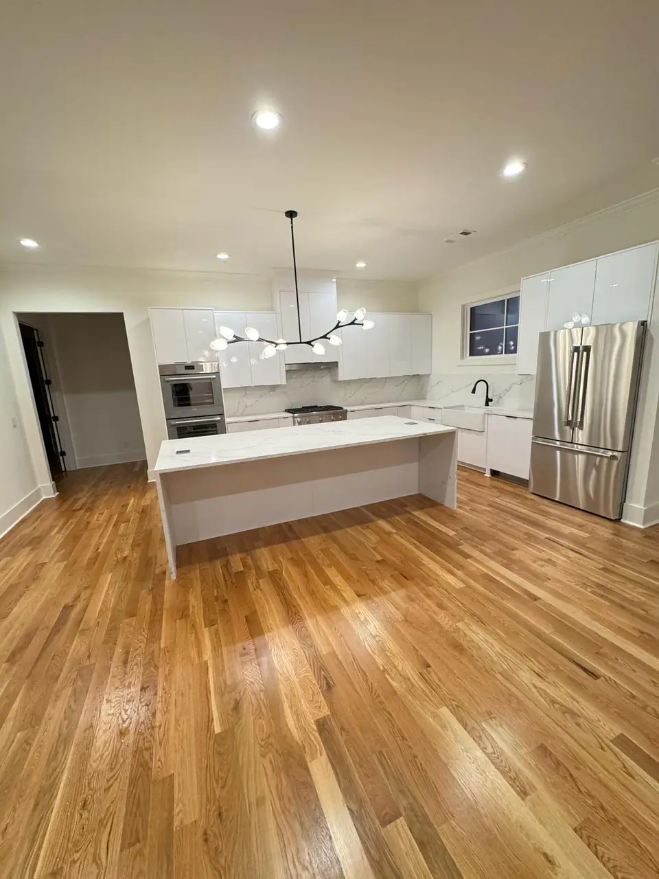 Bright, freshly cleaned kitchen with island and hardwood floors